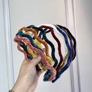 Detailed close-up showing a variety of colorful velvet wavy headbands with pleated texture