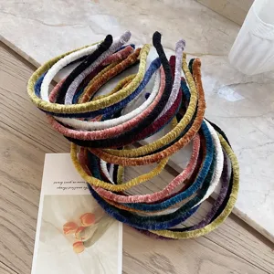 Detail of colorful pleated velvet thin headbands in various solid colors for women