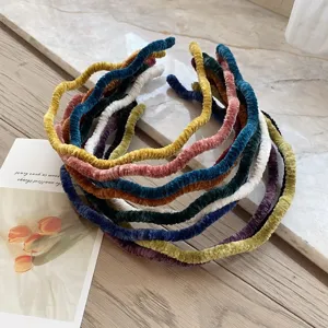 Detail of multi-colored velvet wavy headbands with soft pleated fabric texture