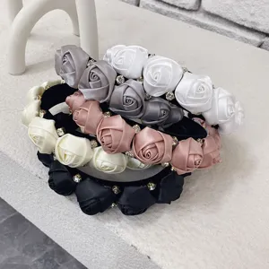 Close-up of 3D satin rose headbands with elegant rhinestone accents in multiple colors