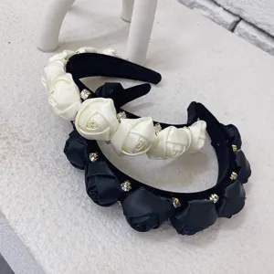 Close-up detail of elegant 3D satin rose flower headbands with sparkling rhinestone accents