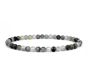 Close-up detail of natural stone beaded bracelet, smooth round beads with unique green tones.