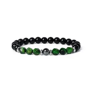 Close-up detail of green tiger eye and black beaded bracelet, showing faceted crystal beads.