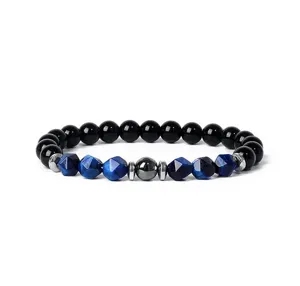 Close up detail of blue tiger eye and black beaded bracelet with metallic spacers and stone.