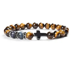 Detail shot of 8mm yellow and blue tiger eye stone bead bracelet featuring a black cross.