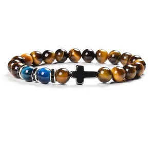 Detailed view of the yellow tiger eye stone and blue chalcedony beaded bracelet with cross.