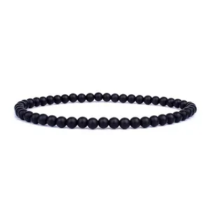 Detailed shot of black matte beaded bracelet, smooth round beads, minimalist everyday jewelry.