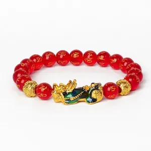 Vue détaillée du bracelet Pixiu en agate rouge 8mm avec perles de mantras dorés et charme chanceux.