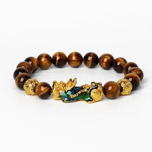 Gros plan détaillé du bracelet de perles en œil de tigre naturel avec charm pixiu doré émaillé.