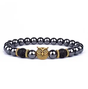Detailweergave van de uilenhanger en de zwarte lavastenen kralen op de modieuze armband.