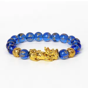 Gros plan sur le détail du bracelet de perles bleues avec pendentif Piyao et mantras.