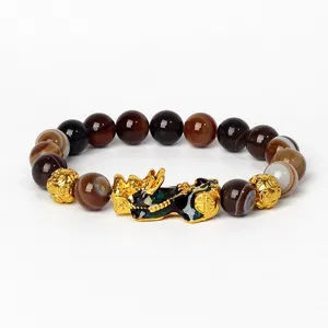 Gros plan détaillé des perles en agate et du charm Pixiu doré sur bracelet élastique.