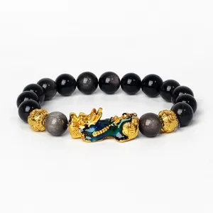 Gros plan détaillé du bracelet de perles d'obsidienne noire avec un charm Pixiu doré et bleu.