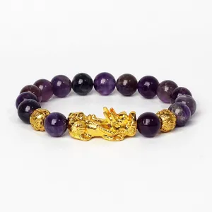 Vue détaillée du bracelet de perles d'améthyste avec charme Pixiu doré et perles brillantes.