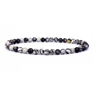 Detailed close-up of natural stone beaded bracelet with black and white webbed patterns.