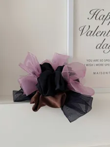 Detailopname van premium satijnen en mesh bow scrunchies in roze, zwart en bruin