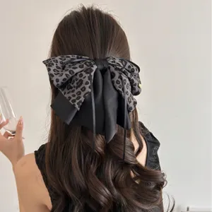 Grande pince à cheveux avec nœud léopard sur de magnifiques cheveux longs ondulés
