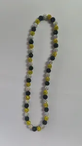 Detailed view of 10mm sparkly clay bead Shamballa necklace in black, gold, and silver