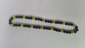 Close-up of 10mm black and yellow sparkling Shamballa disco ball bead necklace detail.