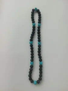 Close-up view of 10mm Shamballa clay disco ball beads in black and turquoise blue