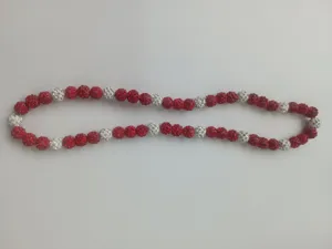 Close-up view of red and white 10mm polymer clay drill ball beads on a Shamballa necklace.