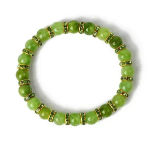 Nahaufnahme eines grünen Jadeperlen-Armbands mit funkelnden Strass-Gold-Abstandshaltern.