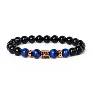 Close-up detail of blue tiger eye stone and black beads bracelet with rose gold cubic spacer.