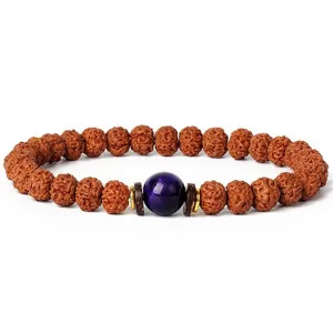 Closeup detail of 7mm rudraksha bead bracelet featuring central purple gemstone and wooden spacers.