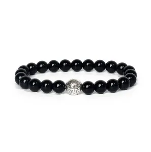 Detail view of 8mm black gemstone beads yoga bracelet featuring a vintage silver charm bead.