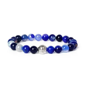 Detailed close-up view of natural blue agate gemstone beads and vintage engraved metal spacer.