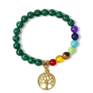 Details of the chakra gemstone bracelet with malachite beads and a gold tree of life pendant.