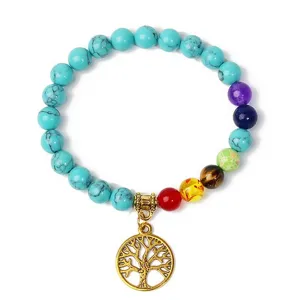 Close-up detail of the chakra stone bracelet featuring a golden tree of life pendant.