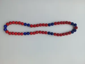 Detailed view of 10mm red and blue clay pavé disco ball beads on a Shamballa necklace
