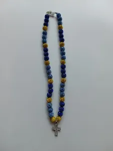 Close-up detail of blue and gold rhinestone pave bead necklace featuring a sparkling cross pendant.