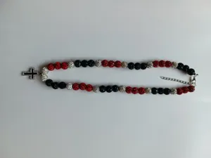 Detailed view of the red black and silver rhinestone shamballa bead necklace with a cross pendant.