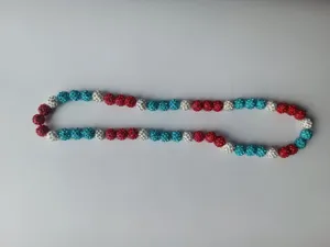 Detailed view of red blue and white rhinestone encrusted clay ball beads necklace