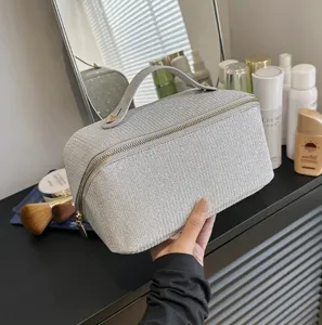 Große glitzernde Kosmetiktasche in Silber, präsentiert in einer Schminktischszene