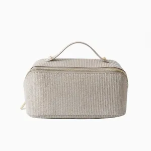 Nahaufnahme der champagnerfarbenen Glitzer-Kosmetiktasche mit goldenen Nieten