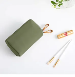 Macro view of a compact olive green mini cosmetic bag with dual leather pulls