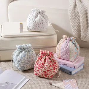 Detailed view of multiple quilted floral drawstring makeup bags in vibrant prints
