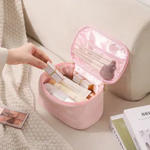 Kosmetiktasche aus Cord mit Pinseln auf einem gemütlichen Sofa