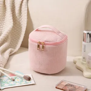 Detailansicht pinker Cord-Kosmetiktasche mit Gold-Reißverschlüssen und Tragegriff im Alltag