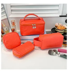 Detailed view of a bright orange PU leather makeup bag set with elegant quilted texture