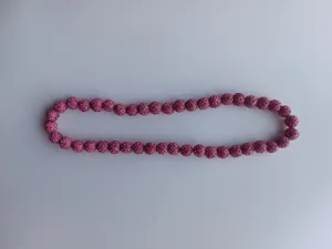 Macro view of pink Shamballa pave clay beads with sparkling rhinestones details.