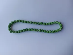 Close-up detail of a green Shamballa necklace with sparkling crystal encrusted clay beads