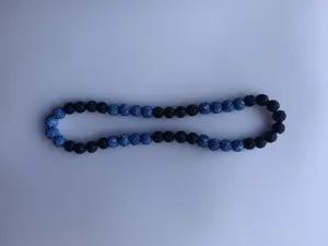 Detailed view of blue and black clay pave disco beads on a Shamballa style necklace