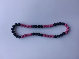 Detail shot of Shamballa clay rhinestone beads on a pink and black elastic necklace