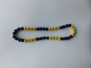 Detailed macro view of black and yellow sparkling Shamballa disco ball bead necklace