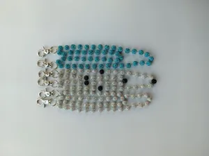 Close-up detail of rhinestone disco ball pants chains with lobster clasps and sparkly beads.