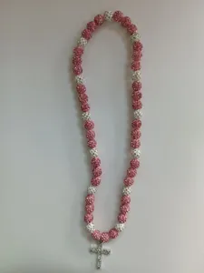 Detail of pink and white rhinestone clay bead necklace with sparkling silver cross pendant